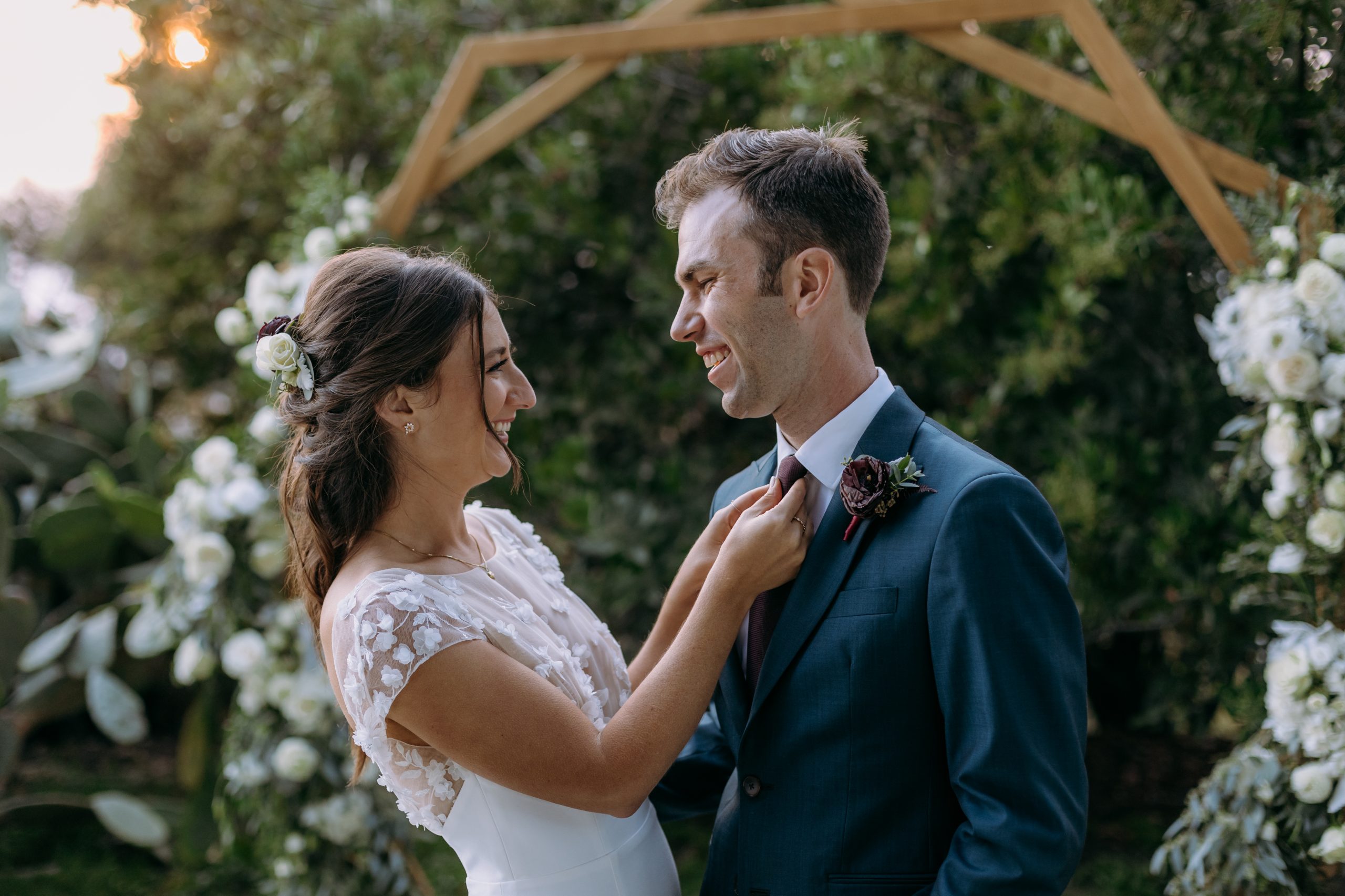 A bride fixing her new husband's tie at the altar.